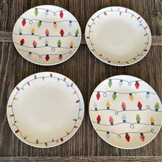 four white plates with christmas lights on them