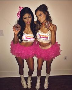 two women in pink tutu skirts holding donuts