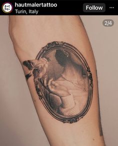 a man's arm with a tattoo on it that has an image of a baby in a frame