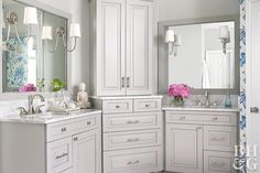 a white bathroom with two sinks and mirrors