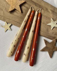 four hotdogs are lined up on a table next to stars and other decorations