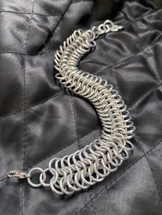 A slinky, lightweight chainmaille bracelet with a euro 6-in-1 weave.  Adjustable clasp, can be made custom length for the best fit. Made with bright aluminum jump rings so it's lightweight, won't tarnish or turn your skin funky colors, water-safe, easy to clean, etc. Metal Link Bracelets With Jump Ring, Metal Chainmail Bracelet, Funky Colors, Chainmail Bracelet, Wire Art Sculpture, Chainmaille Bracelet, Chain Maille Jewelry, Chain Maille, Snake Bracelet