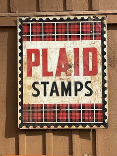 a red and black sign that says plad stamps on the side of a building