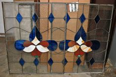 an old stained glass window with blue, red and white designs on it's sides