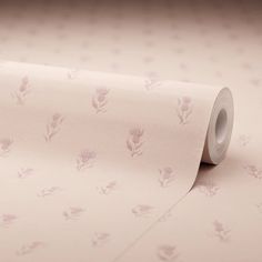 a roll of pink wallpaper with small flowers on the side and dots in the background