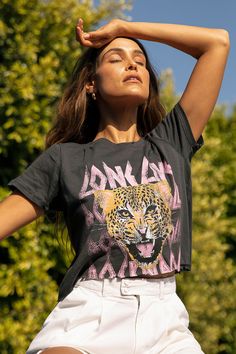 Get a forever fierce look with the Prince Peter Long Live Cheetah Black Distressed Cropped Tee! This 100% cotton tee has a classic cut with edgy distressing throughout, short sleeves, and boxy cropped bodice with a raw cut uneven hem. A fierce cheetah face snarls atop distressed pink font that reads, "long live rock 'n' roll". Fit: This garment fits true to size. Length:  Size small measures 18.5" from shoulder to hem. Bust: Great for any cup size. Waist: Not Fitted - comfortable room throughout Plus Size Biker Shorts Outfit, Cheetah Face, Biker Shorts Outfit, T Shirt Model, Live Rock, Shirt Model, Cropped Tee, Short Sleeve Cropped Top, Print Crop Tops