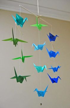 a group of origami birds hanging from strings