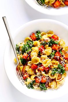 two white bowls filled with pasta and vegetables