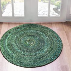 a green rug on the floor in front of a window