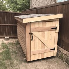 a wooden shed sitting in the middle of a yard