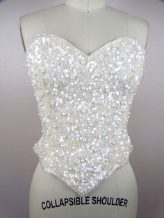 "ABSOLUTELY STUNNING vintage couture piece! It's completely hand sewn, fully embellished with iridescent beading, sequins and pearls. Measurements: Bust - 34\" Waist - 26\" Length - 14\" in the front and 9\" in the back (note, there is a zipper closure in the back going from top to bottom) All of my items come from a smoke-free and pet-free home. If you would like more info or have any questions, please don't hesitate to ask!" Glamorous Embellished Party Bodice, Sequin Sleeveless Fitted Bodice Corset, Wedding Corset With Sequins And Fitted Bodice, Elegant Fitted Sequin Corset, Glamorous Embellished Fitted Corset, Glamorous Fitted Embellished Corset, Glamorous Sequined Corset For Wedding, Embellished Fitted Bodice For Party, Embellished Strapless Corset For Wedding