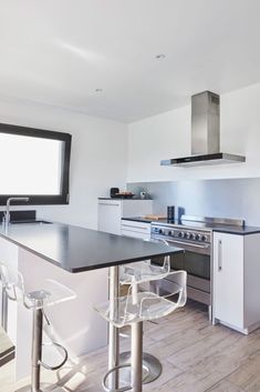 a kitchen with an island and two bar stools in front of the counter top