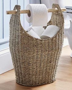 a wicker basket with two rolls of toilet paper hanging from it's side