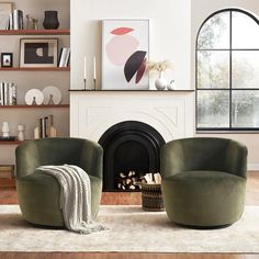 two green chairs sitting in front of a fire place next to a white rug on top of a hard wood floor