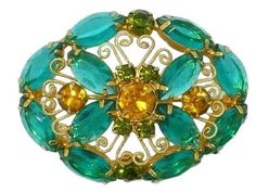 Attributed to DeLizza & Elster green, yellow, gold tone filigree brooch. Measures approximately 1.5 x 2 inches.  While D&E  jewelry was unsigned, there are ways of identifying pieces as genuine D&E by quality, design, and smithing techniques. The elegant design, fine quality metalwork, open-back colored stones, puddling on the back, and the particular fastener confirm its identification as a desirable Juliana d&E piece. The colors and quality of this piece are astounding. The elegant marquise cu Victorian Green Collectible Brooches, Oval Green Brooch Jewelry, Green Costume Jewelry Brooch For Collectors, Green Oval Brooches For Formal Occasions, Ornate Green Brooches For Wedding, Green Costume Jewelry Brooches For Gifting, Green Costume Jewelry Brooches For Gift, Antique Green Filigree Brooches, Green Filigree Brooches For Gifts