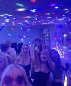 a group of people dancing in a room with disco lights