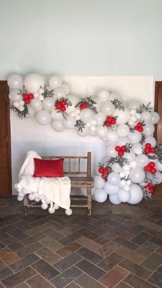 balloons and flowers decorate the wall behind a chair in front of a bench with a red pillow on it