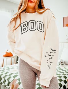 Get into the spooky season spirit with our Boo Sweatshirt, a cozy Halloween crewneck featuring varsity letter designs and a playful bat sleeve print. ABOUT THE SWEATSHIRT Comfort Colors 1466 100% ring-spun cotton Light fabric  OEKO-TEX certified low-impact dyes Relaxed Fit  Size up 1-2 sizes for oversized fit SHIPPING AND PROCESSING All sweatshirts are processed and shipped within 1-7 business days from purchase.  RETURN POLICY We want you to be happy with your purchase! if you need to request a Oversized Fan Apparel Sweatshirt For Fall, Fan Apparel Long Sleeve Sweatshirt For Fall, Fall Fan Apparel Hoodie With Letter Print, Game Day Hoodie With Ribbed Cuffs For Fall, Fall Hoodie With Ribbed Cuffs For Game Day, Ribbed Cuffs Hoodie For Game Day In Fall, Fall Game Day Hoodie With Ribbed Cuffs, Collegiate Hoodie Sweatshirt For Fall, Hooded Tops For Game Day In Fall