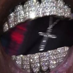 a close up view of a person's mouth with diamonds on it and a cross in the middle