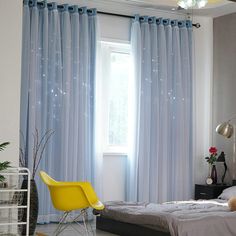 a bed room with a neatly made bed next to a window and a yellow chair