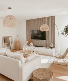 a living room filled with furniture and a flat screen tv mounted on the wall above it