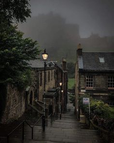 an alley way with stone buildings on both sides and foggy sky in the background