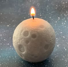 a candle that is sitting on top of a table next to a ball of wax