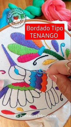 someone is stitching an embroidered item on a table