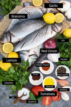 an overhead view of fish, lemons, tomatoes and other ingredients