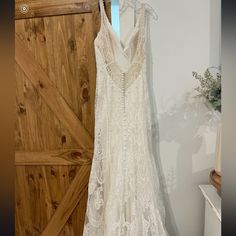 a white dress hanging on a wooden door