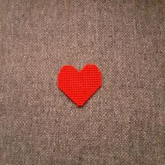 a red heart is placed on a gray surface