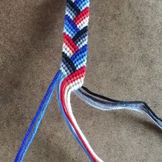 a close up of a multicolored rope on the ground with two wires connected to it