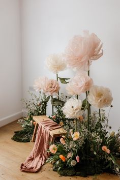 flowers and greenery are arranged on the floor