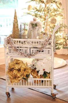 a white basket filled with flowers on top of a wooden floor next to a christmas tree