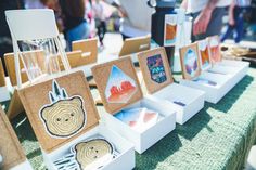 there are many pictures on the table at this outdoor event that is decorated with cork and paper