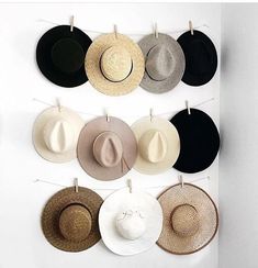 several hats hanging on a wall with clothes pins