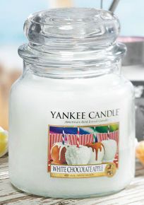 a yankee candle sitting on top of a wooden table