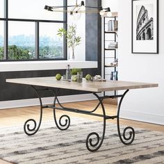 a dining table with metal legs and a wooden top in front of a large window