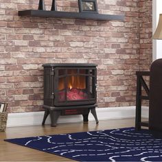 a small stove in front of a brick wall with a blue rug on the floor