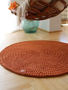 an orange rug is on the floor next to a blue vase