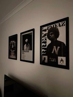 three black and white posters are hanging on the wall