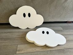 two white clouds sitting on top of a wooden floor