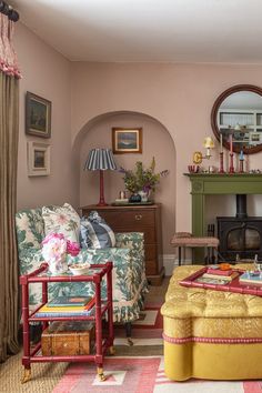 a living room filled with furniture and a fire place under a mirror on the wall