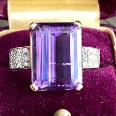 Details: Beautiful vintage mid-century amethyst ring set in 14K yellow gold filigree with diamond side details. The dramatic deep purple amethyst is large, measuring 15.9 x 11.8mm, and is surrounded by 24--1.6mm diamonds. This is a fabulous ring--you will not be disappointed! Please ask all necessary questions prior to placing an order. Measurements: The size is 6 US and can be sized for a fee. The amethyst measures 15.9 x 11.8mm. Ring weighs 6.7 grams. Condition: The overall all condition of th Classic Purple Diamond Ring With Prong Setting, Art Deco Purple Amethyst Ring For Anniversary, Purple Amethyst Art Deco Ring For Anniversary, Classic Purple Diamond Ring For Formal Occasions, Formal Purple Diamond Ring With Prong Setting, Heirloom Amethyst Ring Emerald Cut For Formal Occasions, Formal Heirloom Amethyst Ring Emerald Cut, Elegant Purple Diamond Ring For Formal Occasions, Heirloom Purple Amethyst Ring For Formal Occasions