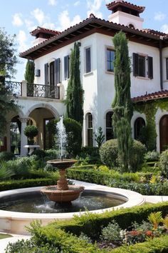 a fountain in front of a large house