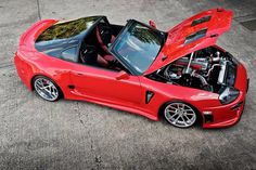 a red sports car with its hood open