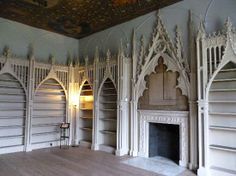 an empty room with wooden flooring and white painted walls, decorated in gothic style architecture