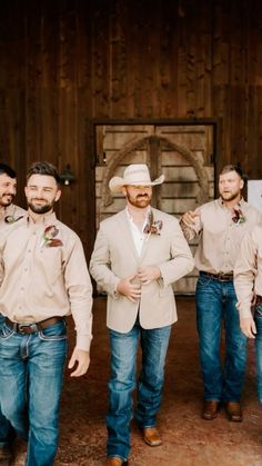 a group of men standing next to each other in front of a wooden wall and door