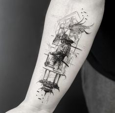 a man's arm with a tattoo on it that has an image of a bird in a cage