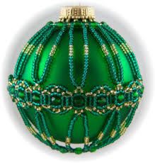 a green ornament with gold trimmings on it's sides and a white background